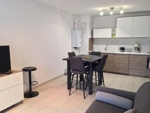 une cuisine avec une table et des chaises dans une pièce dans l'établissement Appartement centre plage à pieds, à Arcachon