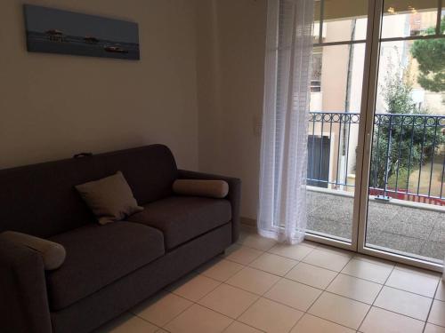 un salon avec un canapé et une grande fenêtre dans l'établissement Appartement centre plage à pieds, à Arcachon