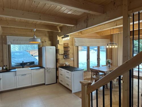 a kitchen with a refrigerator and a dining table at Ski&Chill Rafaczówki in Poronin