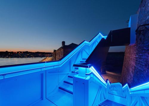 eine Treppe mit blauen Lichtern an der Seite eines Gebäudes in der Unterkunft Royal William Yard Apartments - Large and Luxurious with Free Parking in Plymouth