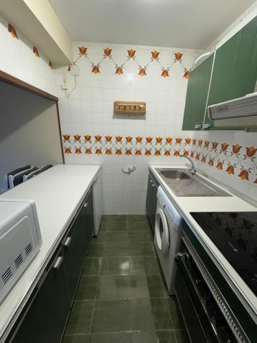 a kitchen with a sink and a washing machine at Céntrico apartamento con vistas en Formigal - Entrada 24h sin llaves in Formigal