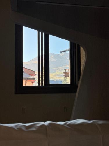 a window in a bedroom looking out at a mountain at Céntrico apartamento con vistas en Formigal - Entrada 24h sin llaves in Formigal