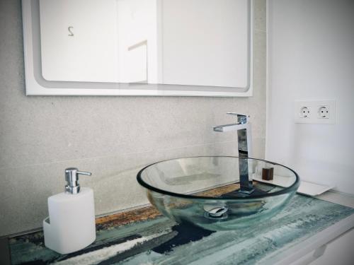 Un lavabo de baño con un recipiente de vidrio sobre una encimera. en Casa rural Atalanta de la Vera, en Jaraíz de la Vera
