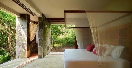 a bedroom with a bed and a window at Cocolia Hotel in Mazunte