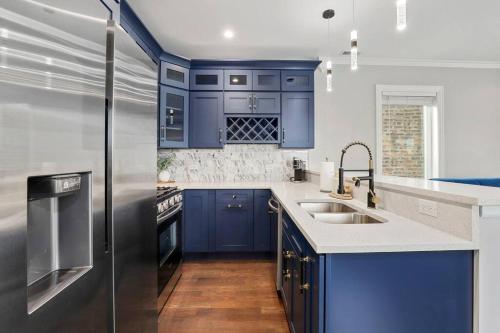 a kitchen with blue cabinets and a stainless steel refrigerator at LuxHome Chicago 8 mins Downtown in Chicago