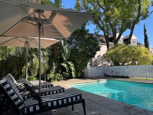 two chairs and an umbrella next to a swimming pool at The Prime Spot in Worcester