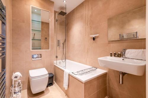a bathroom with a sink and a toilet and a shower at Gorgeous Kentish Town Flat in London