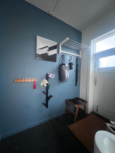 Homely flat with amazing views في ريكيافيك: غرفة ذات جدار أزرق مع أكياس وطاولة