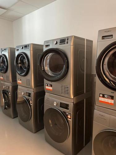 four washers and dryers are lined up in a room at Small cozy apartment, coffee and parking free in Trnávka