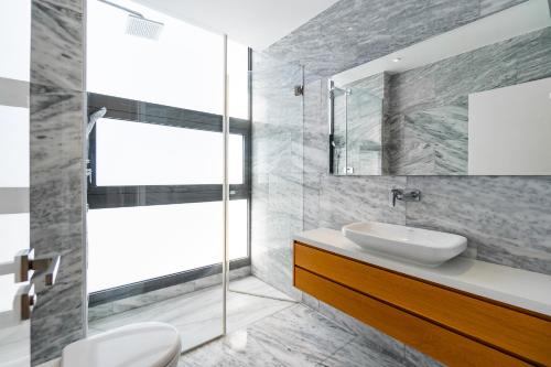 a bathroom with a sink and a mirror at Villa Laurus 4 by Ezoria Villas in Paphos