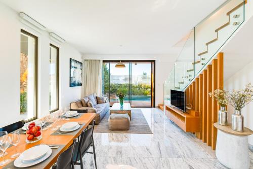 a living room with a table and a couch at Villa Laurus 4 by Ezoria Villas in Paphos