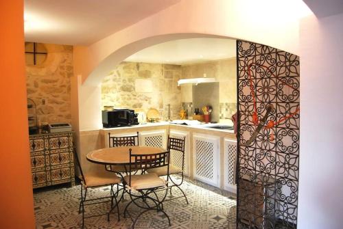 - une cuisine avec une table, des chaises et une table dans l'établissement Traditional Riad Camargue Arles, à Arles
