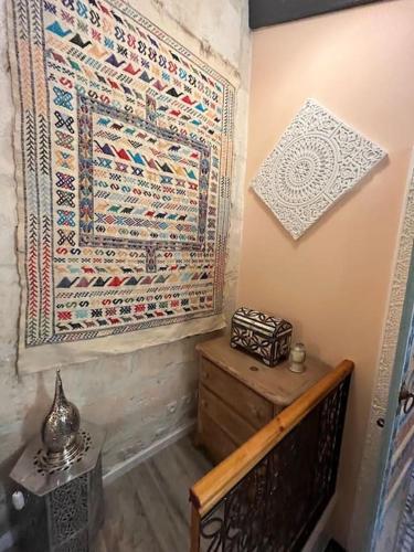 Cette chambre dispose d'un tapis suspendu au mur et d'une table avec un banc. dans l'établissement Traditional Riad Camargue Arles, à Arles