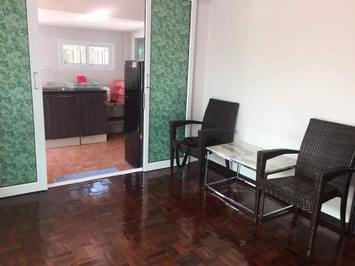 a living room with chairs and a table and a kitchen at Nicha Pool Villa by Nichahome in Hua Hin
