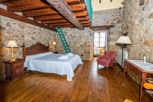 a bedroom with a bed and a chair in a building at Casa Tenada in Robledo