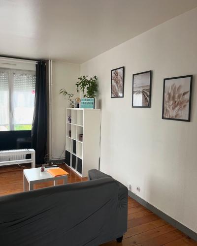 - un salon avec un canapé et un réfrigérateur blanc dans l'établissement Très joli T1 à Lambezellec avec parking gratuit, à Brest