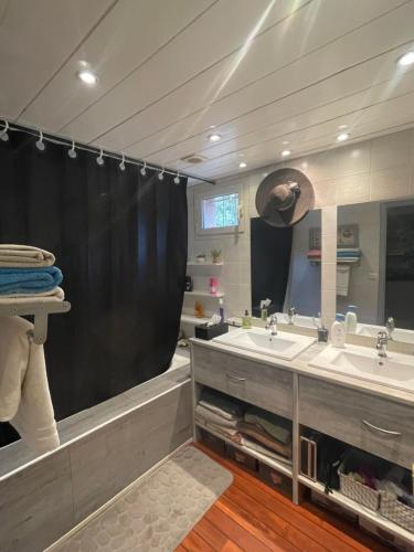 une salle de bain avec deux lavabos et un grand miroir dans l'établissement Perle du Maquis, à Porto-Vecchio