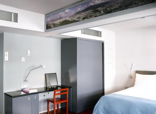 a bedroom with a bed and a desk with a computer at Periscope in Athens
