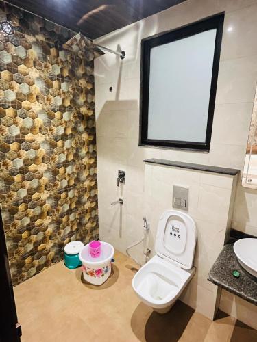 a bathroom with a toilet and a sink at Goel Villa and Hotel in Allāhābād Junction