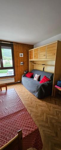 里雾诗Studio pieds des pistes les Houches Vallée de Chamonix的一间卧室，床上有红色枕头