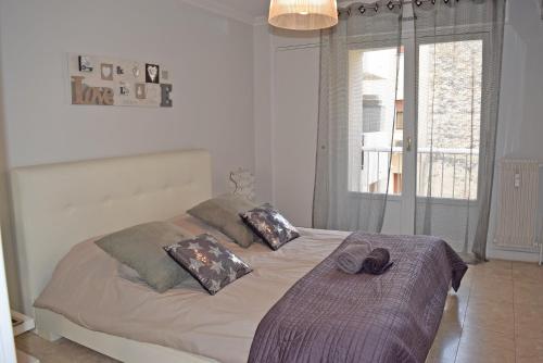 une chambre avec un lit avec des oreillers et une fenêtre dans l'établissement Canada, à Cannes