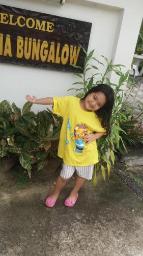 a young girl standing in front of a building at Wattana Bungalow in Nai Yang Beach