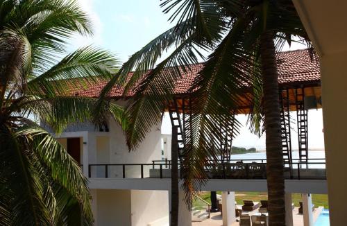 a view of a building with palm trees in front of it at Villa Santé by The Serendipity Collection in Kalpitiya