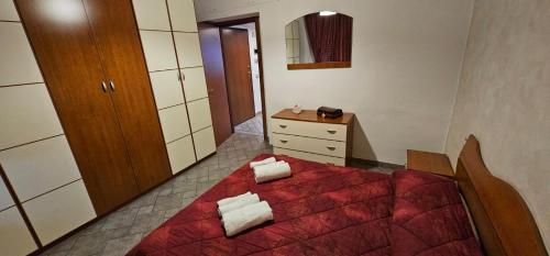 a bedroom with a red bed and a dresser at appartamento palombina vista mare in Ancona