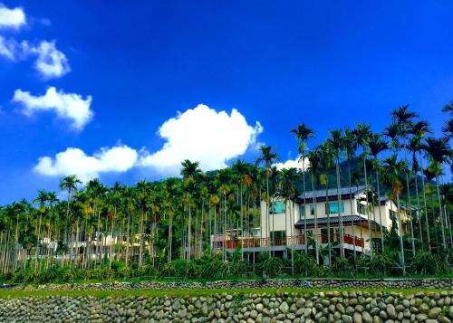 a house with palm trees in the background at Love B&B in Sanyi