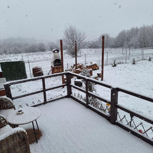 a snow covered yard with a fence and a field at Cabana A-frame Moon Predelut in Predeluţ
