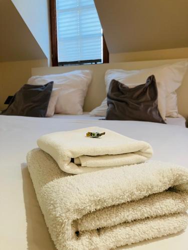 a pile of towels sitting on top of a bed at Downtown Apartments DeLuxe in Győr