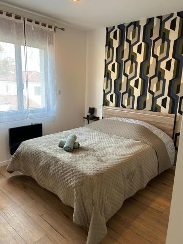 a bedroom with a bed with a teddy bear on it at Paisible MAISON familiale - 4 Chambres - 2 SDB - terrasse et jardin - parking privé - Limoges in Limoges