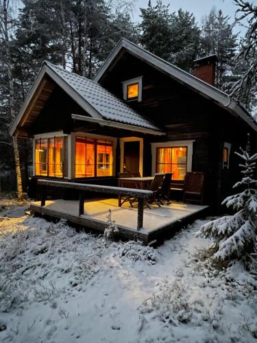 a small house with a porch in the snow at Mökki Aapola in Puumala