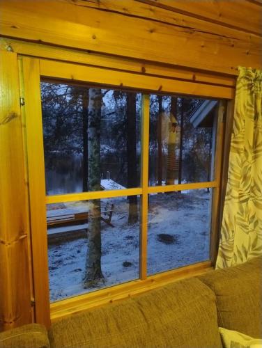 a window with a view of a snow covered yard at Mökki Aapola in Puumala