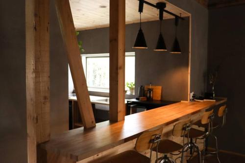 a kitchen with a wooden bar with stools at Tob-inn Myoko in Myoko