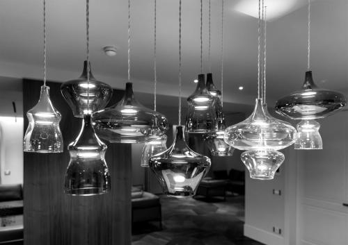 a group of glass bottles hanging from a ceiling at AF Duomo - Milano Luxury Suites in Milan