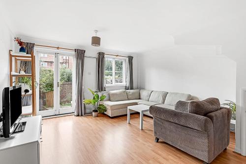 a living room with a couch and a tv at Beautiful Three-Bedroom House in Richmond in Richmond upon Thames
