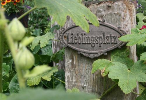 a sign on a wooden post in a garden at Ferienhof Lucht in Mühbrook