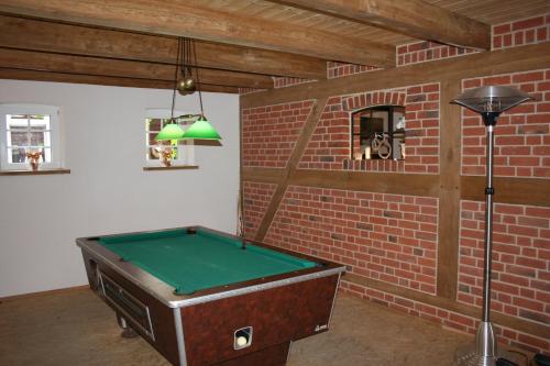 a room with a pool table in a brick wall at Ferienhof Lucht in Mühbrook
