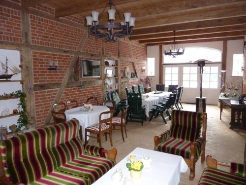 a restaurant with tables and chairs and a brick wall at Ferienhof Lucht in Mühbrook