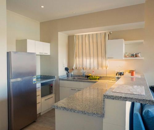 a kitchen with white cabinets and a stainless steel refrigerator at El Gouna - BIRD NEST in Hurghada