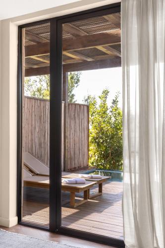 a glass door leading to a deck with a bench at Gordonia Ma'ale Hahamisha in Maale Hachamisha