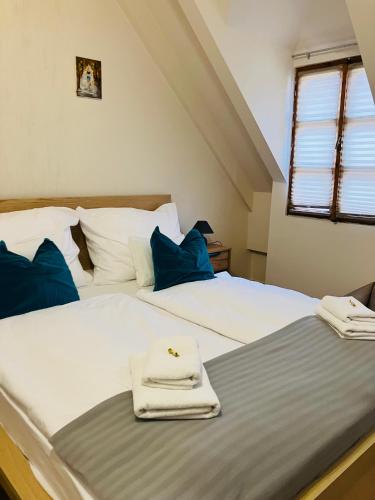 two beds in a room with towels on them at Downtown- Családi Apartman in Győr