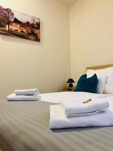 a bedroom with two towels on a bed at Downtown- Családi Apartman in Győr