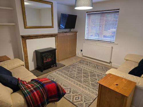 a living room with a fireplace and a couch at Little Willows in Handcross