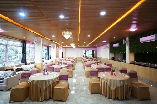 a large banquet hall with tables and chairs at Treenz Hotel in Gangtok