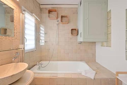 une salle de bain blanche avec une baignoire et un lavabo dans l'établissement Loge de l'Opéra à 200 m du Palais des Papes, à Avignon