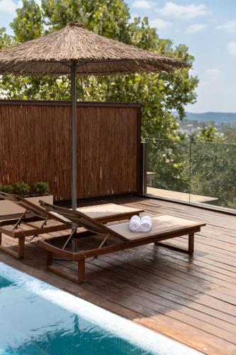 a wooden deck with an umbrella and a pool at Gordonia Ma'ale Hahamisha in Maale Hachamisha