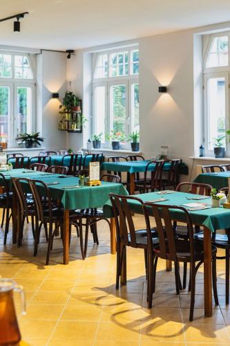 卡尔帕奇Perła Sudetów by Stay inn Hotels的用餐室配有绿色的桌椅