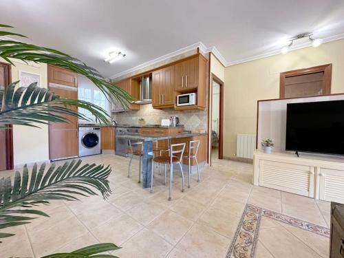 a large kitchen with a table and a tv at Apartamento en centro de Laredo in Laredo